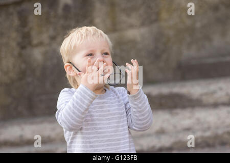 Happy child with falling down glasses, outdoors Stock Photo