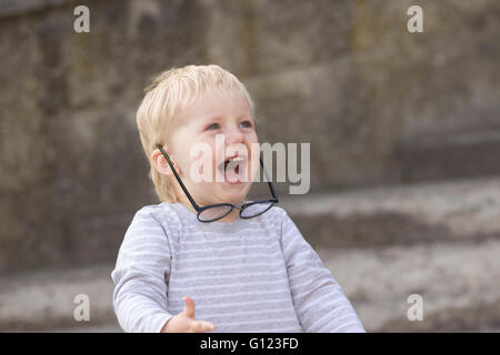 Happy child with falling down glasses, outdoors Stock Photo