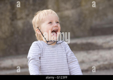 Happy child with falling down glasses, outdoors Stock Photo