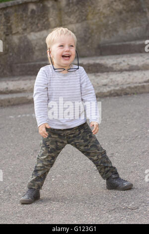 Happy child with falling down glasses, outdoors Stock Photo