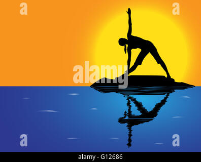 A woman silhouette performing triangle pose on a rock in the sea Stock Photo