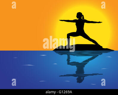 A woman silhouette performing warrior pose on a rock in the sea Stock Photo