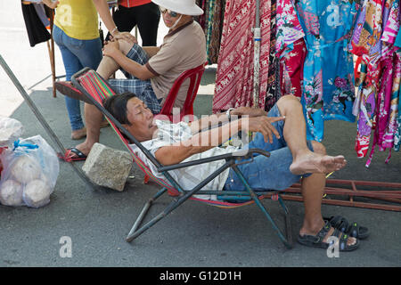 A stall holder relaxes in a market in Nha Trang Vietnam Stock Photo