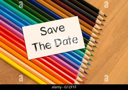 Save the date text concept and colored pencil on wooden background Stock Photo