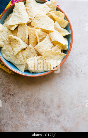 Bowl of fresh tortilla chips on stone surface with copy space.  View from above Stock Photo