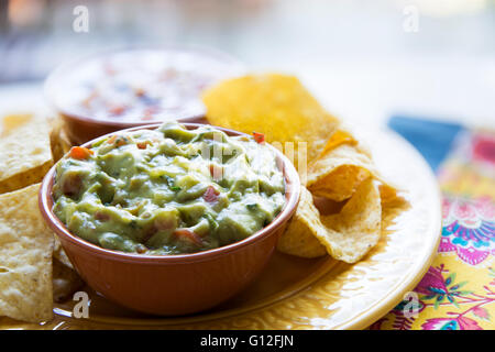 Fresh guacamole in a bowl with tortilla chips Stock Photo