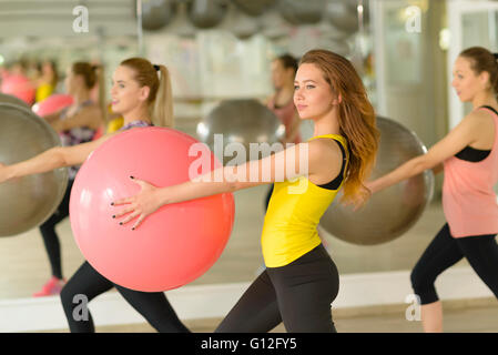 People exercising with fitness ball at gym Stock Photo
