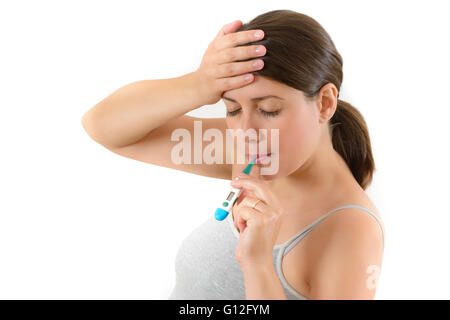 Young woman checking her temperature using oral thermometer Stock Photo