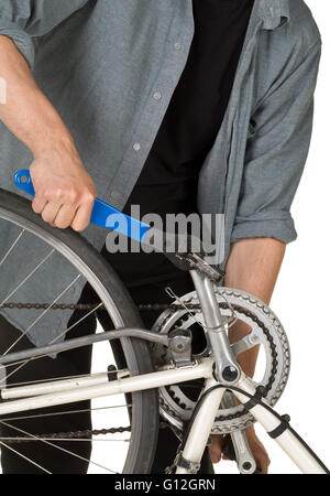 Man fixing pedals on a bicycle over white background Stock Photo
