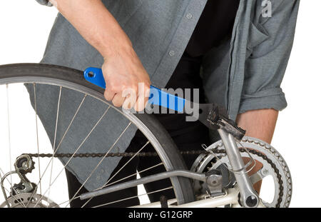 Man fixing pedals on a bicycle over white background Stock Photo