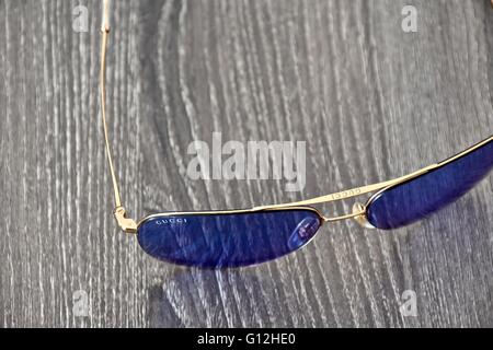 A pair of Gucci sun glasses on a wood surface Stock Photo