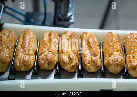 Conveyor line with eclairs. Stock Photo