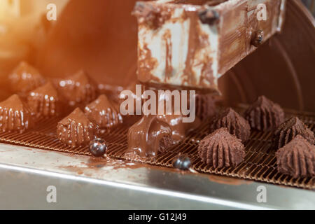 Machine pouring liquid on candies. Stock Photo