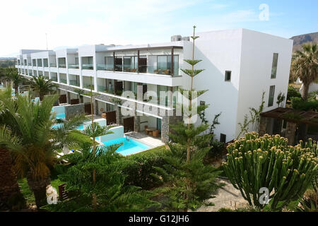 HERAKLION, CRETE, GREECE - MAY 13, 2014: The blue sky, modern building of villa with balconies, swimming-pool and palms in hotel Stock Photo