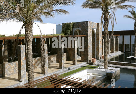 HERAKLION, CRETE, GREECE - MAY 13, 2014: The blue sky, swimming-pool, modern building with columns and palms in luxury hotel. Stock Photo