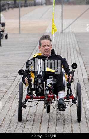 A middle aged man on a recumbent bicycle on the boardwalk in Brighton Beach, Brooklyn, New York Stock Photo