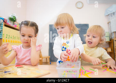 kids group playing puzzle and other board games in kindergarten Stock Photo