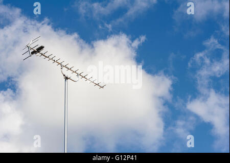 Television antenna on a rooftop, with extra long support. Stock Photo