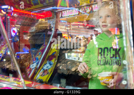 Young girl reflected in the glass of an Amusement arcade on Morecambe seafront, UK Stock Photo