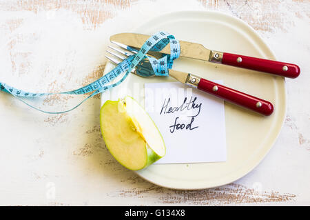 Weight loss concept with vintage plate, silverware and green apple on rustic wooden backgrounf Stock Photo
