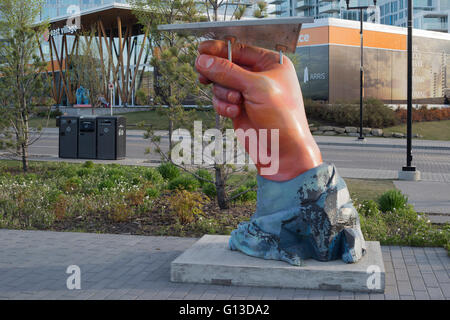 Sculpture of hand holding paper plane in East Village, Calgary Stock Photo