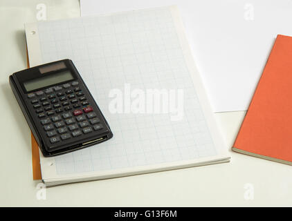 The concept of learning shown with a calculator on a background of graph paper Stock Photo