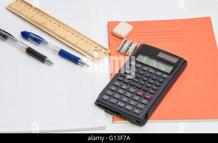 The concept of learning shown with a calculator & pens on a background of graph paper Stock Photo
