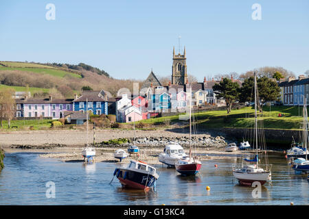 View along Afon Aeron River estuary to church with boats moored in harbour on an incoming tide in coastal town. Aberaeron Wales Stock Photo