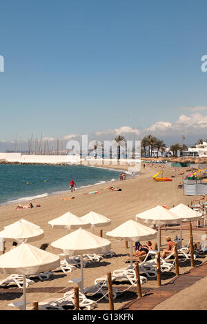 People sunbathing on Playa de la Venus - Marbella Beach, Marbella, Costa del Sol, Andalusia, Spain Stock Photo