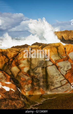 Mosaic patterns on the sandstone cliffs and crashing waves at Point Lobos State Natural Reserve and California’s Big Sur coast. Stock Photo