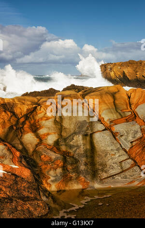 Mosaic patterns on the sandstone cliffs and crashing waves at Point Lobos State Natural Reserve and California’s Big Sur coast. Stock Photo