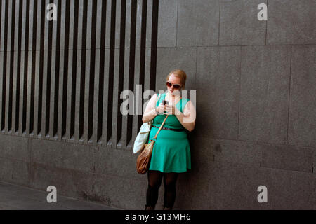 Woman in King's Cross using her mobile phone Stock Photo