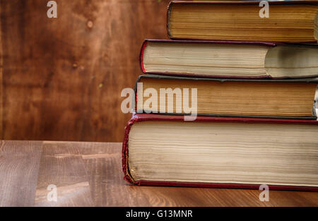 Vintage photo of books of different thicknesses on a wooden table Stock Photo