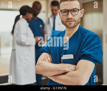 Serious surgeon in front of team of doctors having a meeting at hospital Stock Photo