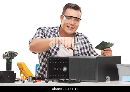 Young PC repairman fixing a broken desktop computer isolated on white background Stock Photo