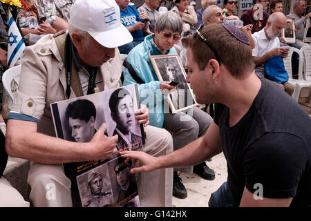 Jerusalem, Israel. 8th May, 2016. A young Israeli man reacting to photos of Russian-Israeli World War II veterans during a honor ceremony commemorating 71 years since the Allies’ victory over Nazi Germany in World War II, in the center of Jerusalem Credit:  Eddie Gerald/Alamy Live News Stock Photo