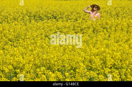 Dorset, UK. 8th May, 2016. One young woman has found how amazingly colourful the UK countryside can be at this special time of the year and when the sun shone today (Sun) even better! Laura Dean (26) pictured enjoying each of three vibrant and vivid displays located, within a few miles of her home at Weymouth, Dorset. The 5acre carpet of, Sea Pinks (Thrift) are next to the 18mile long Chesil Beach, one of the largest such areas of the plants in the UK.  Credit:  Dorset Media Service/Alamy Live News Stock Photo