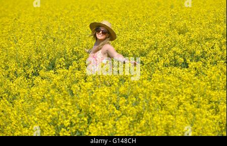 Dorset, UK. 8th May, 2016. One young woman has found how amazingly colourful the UK countryside can be at this special time of the year and when the sun shone today (Sun) even better! Laura Dean (26) pictured enjoying each of three vibrant and vivid displays located, within a few miles of her home at Weymouth, Dorset. The 5acre carpet of, Sea Pinks (Thrift) are next to the 18mile long Chesil Beach, one of the largest such areas of the plants in the UK.  Credit:  Dorset Media Service/Alamy Live News Stock Photo