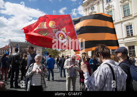 Prague, Czech Republic. 08th May, 2016. Two men waves a flag with the arms of the Czechoslovakian Communist party and an orange black flag, the colors of St. George ribbon used by pro Putin rebels in Eastern Ukraine. © Piero Castellano/Pacific Press/Alamy Live News Stock Photo