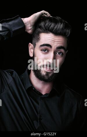 Portrait of a young man, one hand behind his head Stock Photo
