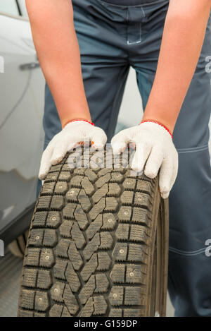 car tire and mechanic hand gloves closeup Stock Photo