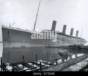 The Titanic sitting in the fitting-out basin at Harland and Wolff in Belfast, Ireland. The Titanic steamship was the largest ship ever built at the time, measuring 268 meters long and weighing 67,000 tonnes. The Titanic's hull had 16 watertight compartmen Stock Photo