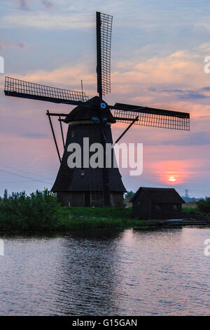 Blue sky and pink clouds on the windmill reflected in the canal at dawn, Kinderdijk, Rotterdam, South Holland, Netherlands Stock Photo