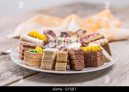 Small cakes with different stuffing on white plate Stock Photo