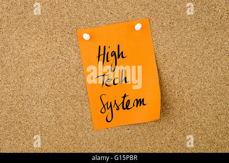 High Tech System written on orange paper note pinned on cork board with white thumbtacks, copy space available Stock Photo
