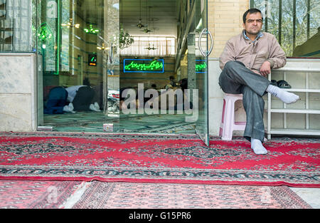 Muslim businessmen take a prayer break in their neighborhood in Hamadan, Iran. Stock Photo