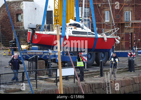 Mobile Crane lifting yacht into harbour, North Berwick Stock Photo