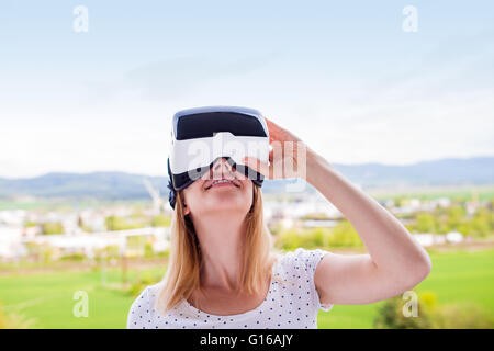 Woman wearing virtual reality goggles standing in a kitchen Stock Photo