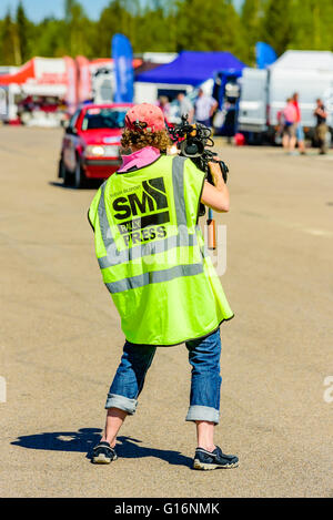 Emmaboda, Sweden - May 7, 2016: 41st South Swedish Rally in service depot. Female cameraman documenting life in the depot here s Stock Photo