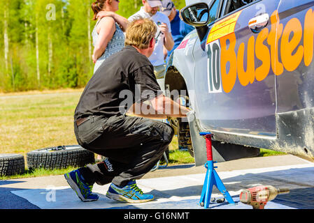 Emmaboda, Sweden - May 7, 2016: 41st South Swedish Rally in service depot. Mechanic working at the front wheelhouse of team Joha Stock Photo